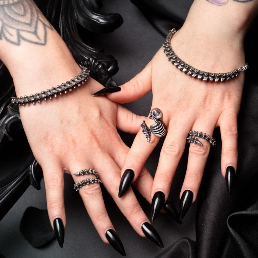 Alchemy Gothic A148 pewter spine bracelets front view showing two hands wearing the anatomical gothic vertebrae jewelry.