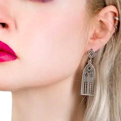 Restyle Altarium women's gothic earring in silver color close-up view showing a single earring worn on an ear.