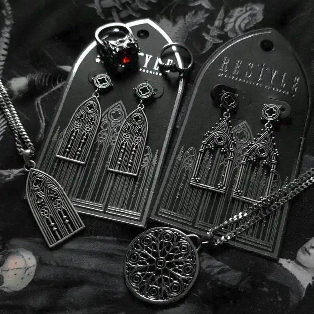 Restyle Altarium gothic earrings in silver color showing the decorative cathedral window display card.