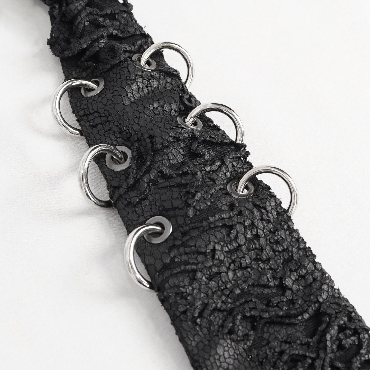 Devil Fashion AS148 womens black dark punk tie close-up focusing on the silver metal O-rings decoration.