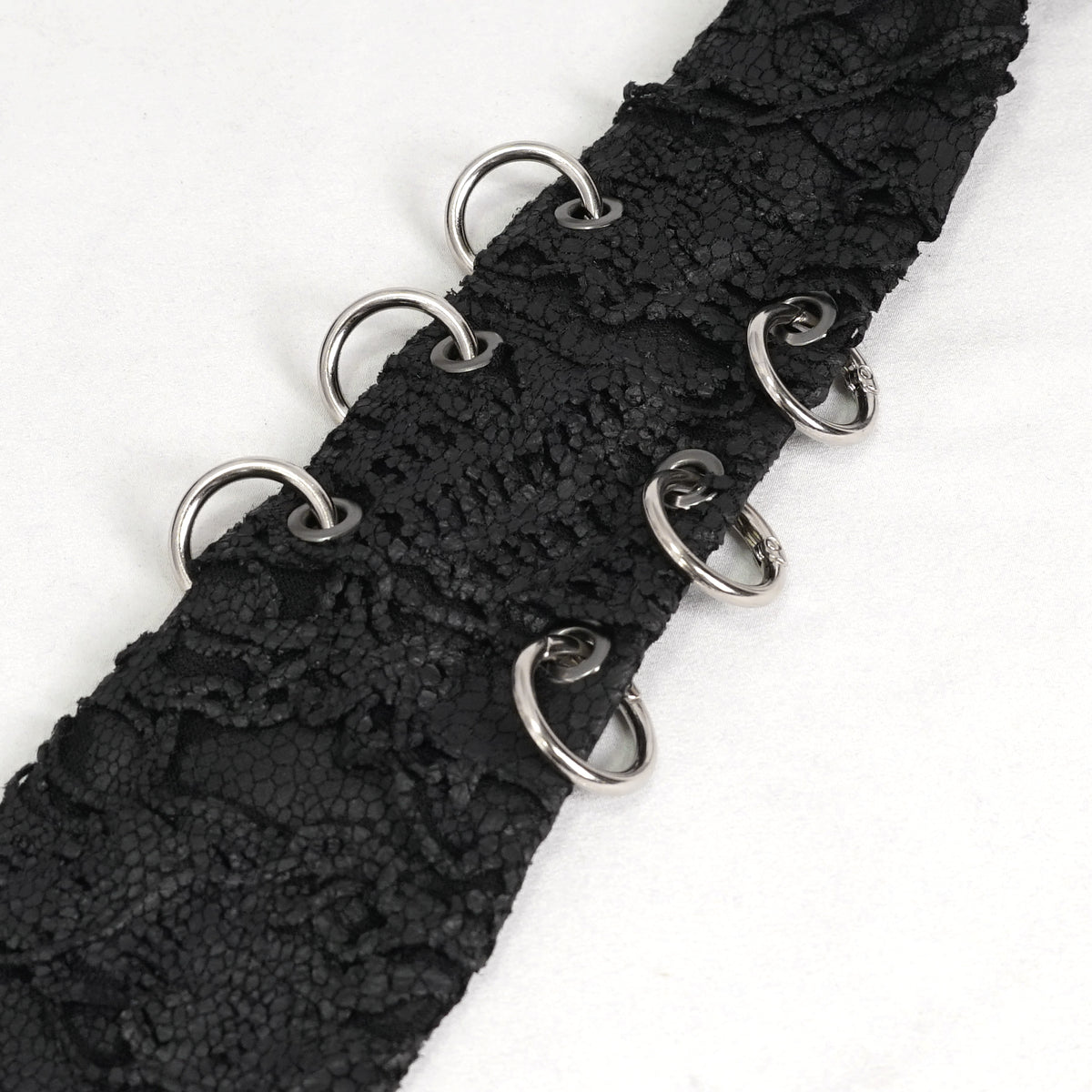 Devil Fashion AS157 mens black dark punk tie close-up focusing on the silver metal O-rings decoration.