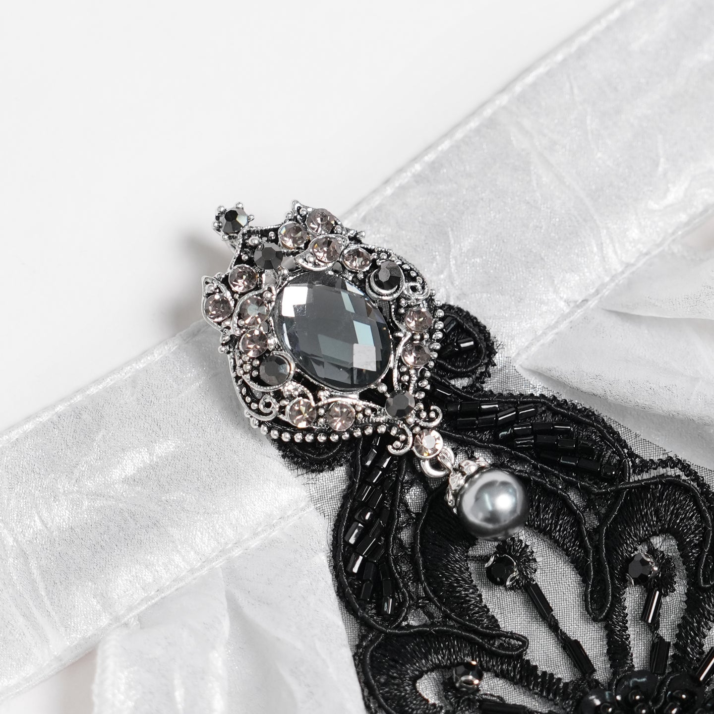 Devil Fashion AS28802 womens white and black Victorian jabot focusing on a metal brooch with a large crystal stone.