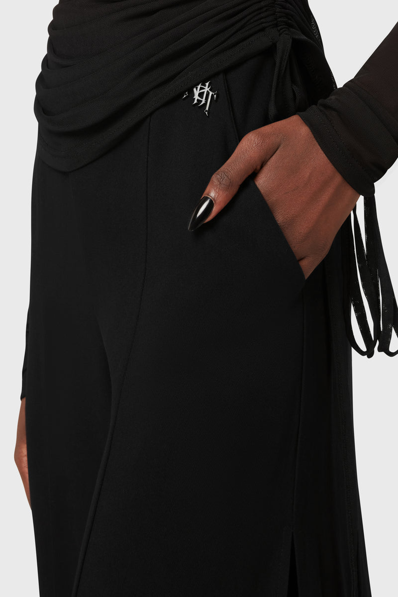 Kihilist Deteriorate women's pants in black showing a side view detail of the front pocket and embossed logo.