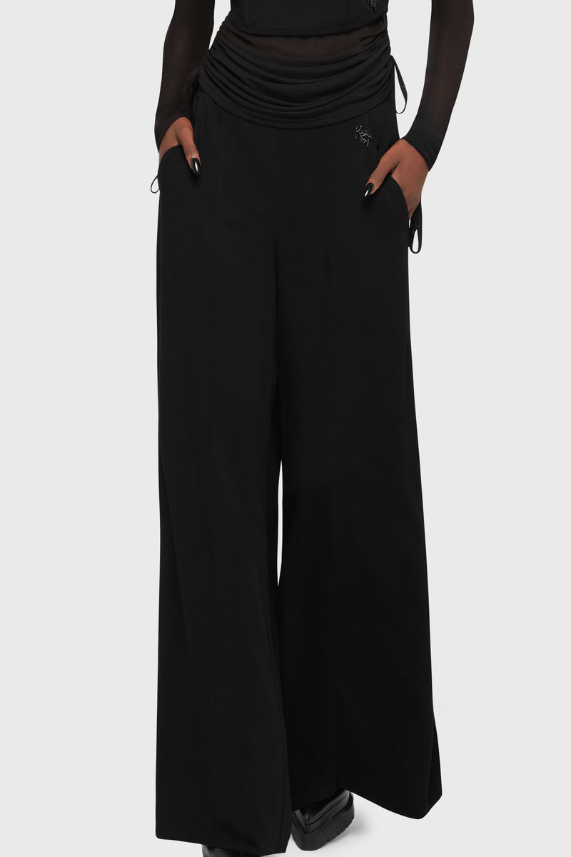 Kihilist Deteriorate women's gothic pants in black showing a front view with a high waist and pockets.