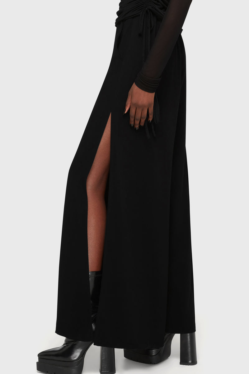 Kihilist Deteriorate women's pants in black showing a side view with a high slit and flowing fabric.