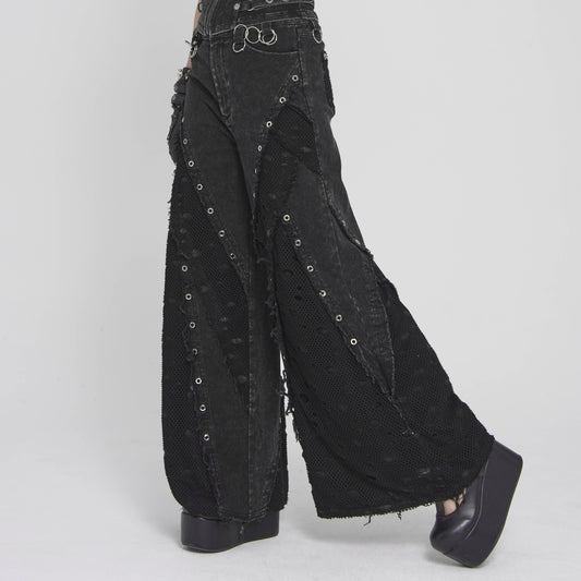 Devil Fashion PT292 black pants side view showing wide flared silhouette with metal eyelets along the denim seams.